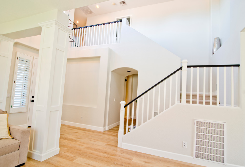 Photo of a large country carpeted u-shaped staircase in Phoenix with carpet risers and wood railing.