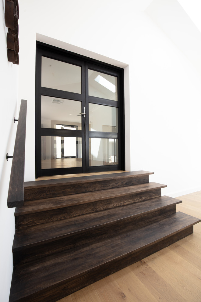 This is an example of a contemporary wood straight staircase in Wollongong with wood risers and wood railing.