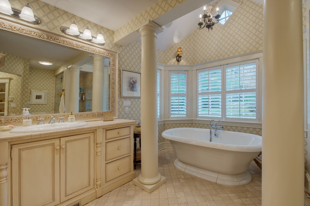 Traditional bathroom in Boston with a freestanding tub, a drop-in sink, beaded inset cabinets, beige cabinets and multi-coloured walls.