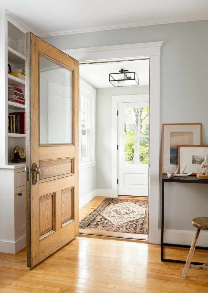 This is an example of a transitional vestibule in Boston with medium hardwood floors, a single front door, a medium wood front door and brown floor.
