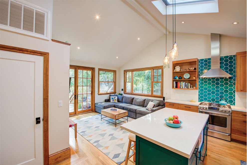 Medium sized contemporary l-shaped open plan kitchen in San Francisco with a built-in sink, shaker cabinets, medium wood cabinets, granite worktops, white splashback, metro tiled splashback, stainless steel appliances, light hardwood flooring, an island, white worktops and a vaulted ceiling.