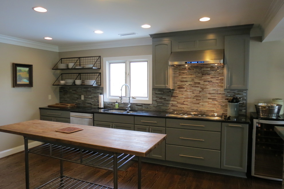 Inspiration for a large transitional dark wood floor and brown floor home design remodel with a double-bowl sink, recessed-panel cabinets, gray cabinets, granite countertops, multicolored backsplash, stone tile backsplash, stainless steel appliances and two islands