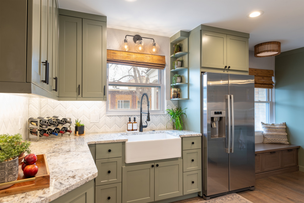 Design ideas for a small rural l-shaped kitchen/diner in Denver with a belfast sink, flat-panel cabinets, green cabinets, granite worktops, white splashback, stainless steel appliances, dark hardwood flooring, a breakfast bar, brown floors and white worktops.