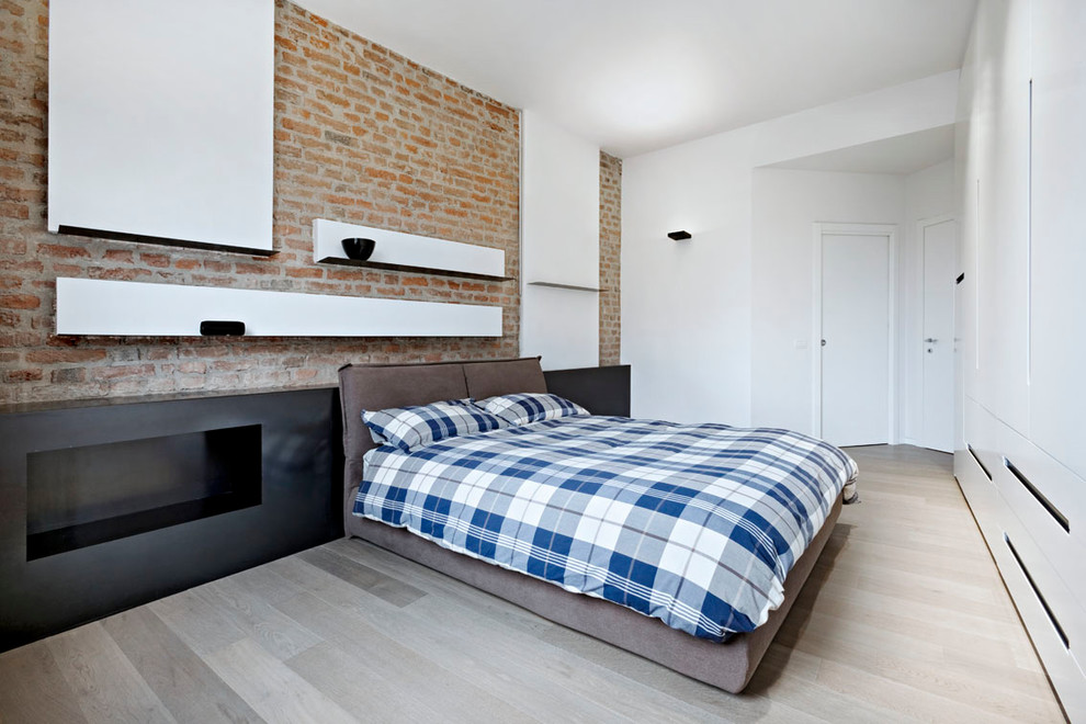 Design ideas for a large industrial master bedroom in Milan with light hardwood floors and beige floor.