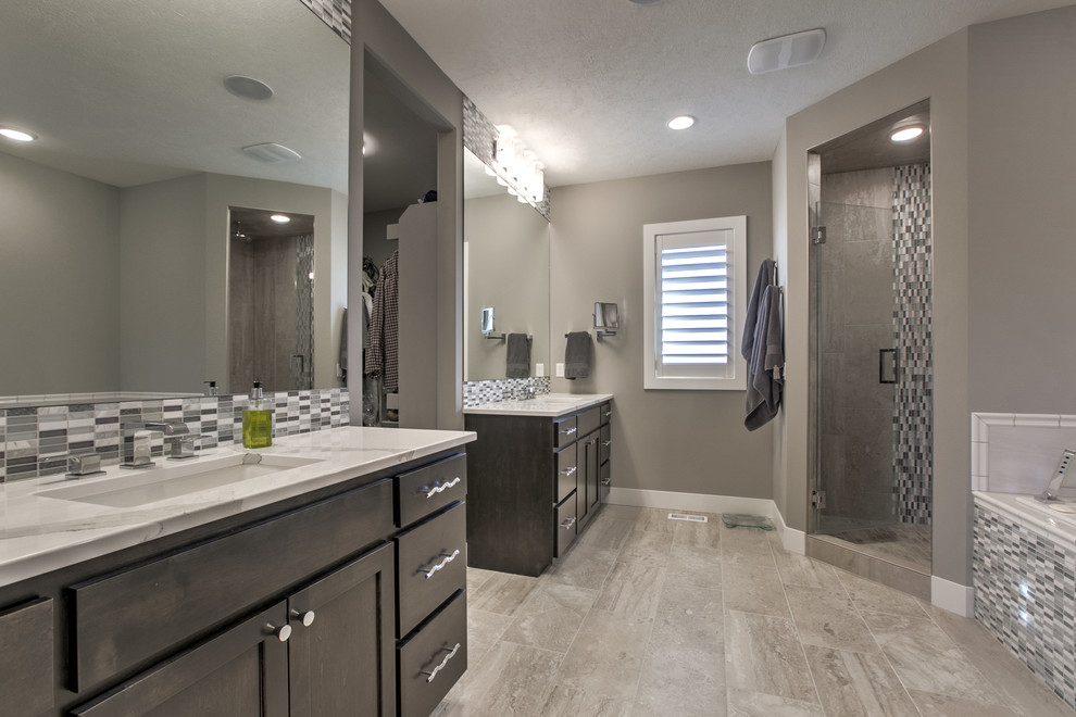 Drop-in bathtub - transitional porcelain tile drop-in bathtub idea in Omaha with shaker cabinets, dark wood cabinets, an undermount sink and quartzite countertops