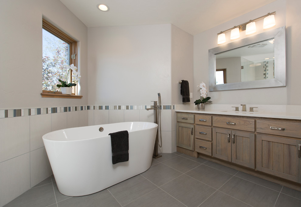 Mid-sized transitional kids bathroom in Albuquerque with raised-panel cabinets, medium wood cabinets, a corner shower, a one-piece toilet, gray tile, porcelain tile, grey walls, porcelain floors, an undermount sink and quartzite benchtops.