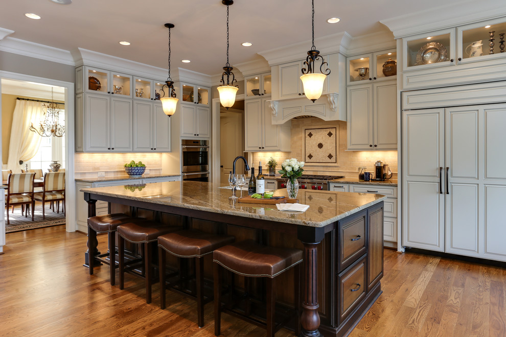 This is an example of a traditional kitchen in Raleigh with a farmhouse sink, raised-panel cabinets, white cabinets, beige splashback, panelled appliances and with island.