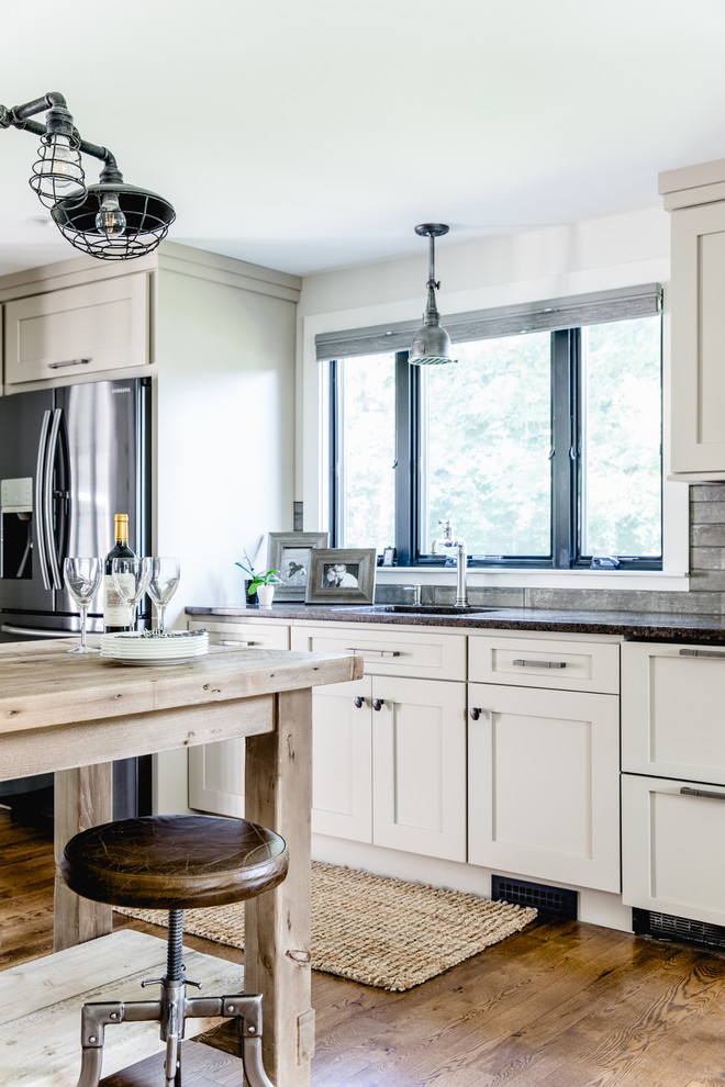 Design ideas for a transitional u-shaped kitchen in Boston with an undermount sink, shaker cabinets, white cabinets, quartz benchtops, grey splashback, stainless steel appliances, medium hardwood floors and with island.
