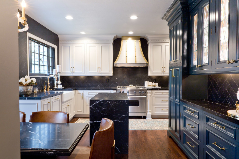 Inspiration for a mid-sized traditional u-shaped eat-in kitchen in Chicago with a farmhouse sink, flat-panel cabinets, white cabinets, marble benchtops, black splashback, marble splashback, stainless steel appliances, medium hardwood floors, with island, brown floor and black benchtop.