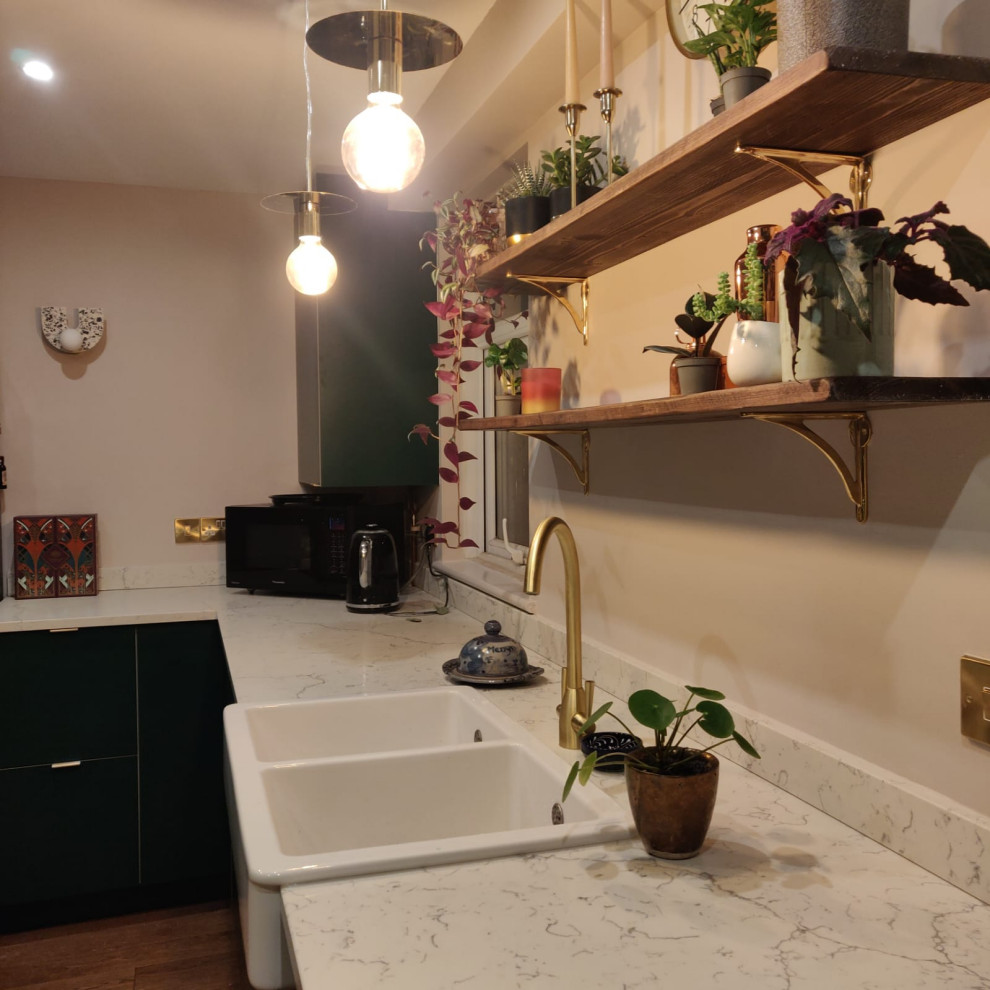 This is an example of a large scandinavian l-shaped open plan kitchen in London with a farmhouse sink, flat-panel cabinets, white cabinets, quartzite benchtops, multi-coloured splashback, engineered quartz splashback, panelled appliances, laminate floors and multi-coloured benchtop.