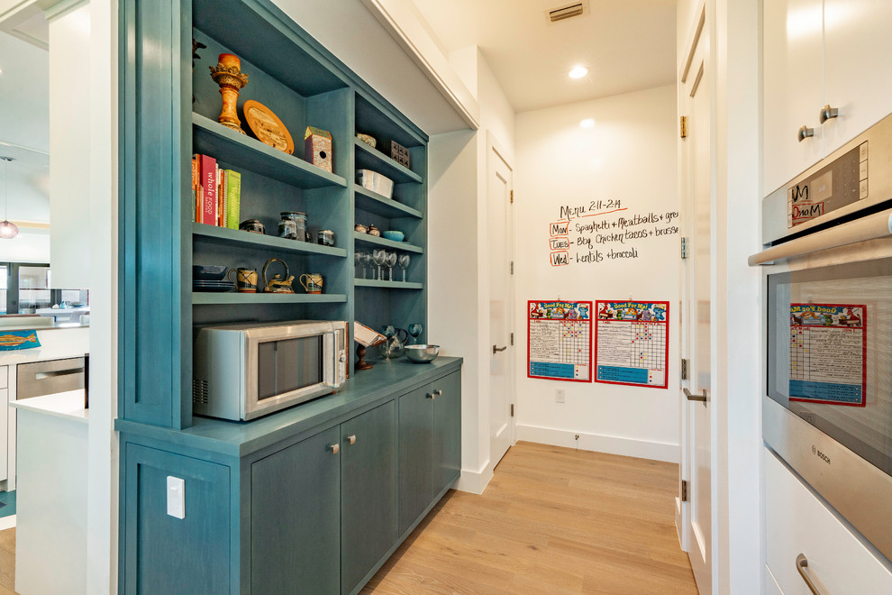 Inspiration for a large traditional single-wall kitchen pantry in Austin with shaker cabinets, blue cabinets, wood benchtops, stainless steel appliances, medium hardwood floors, no island, beige floor and blue benchtop.