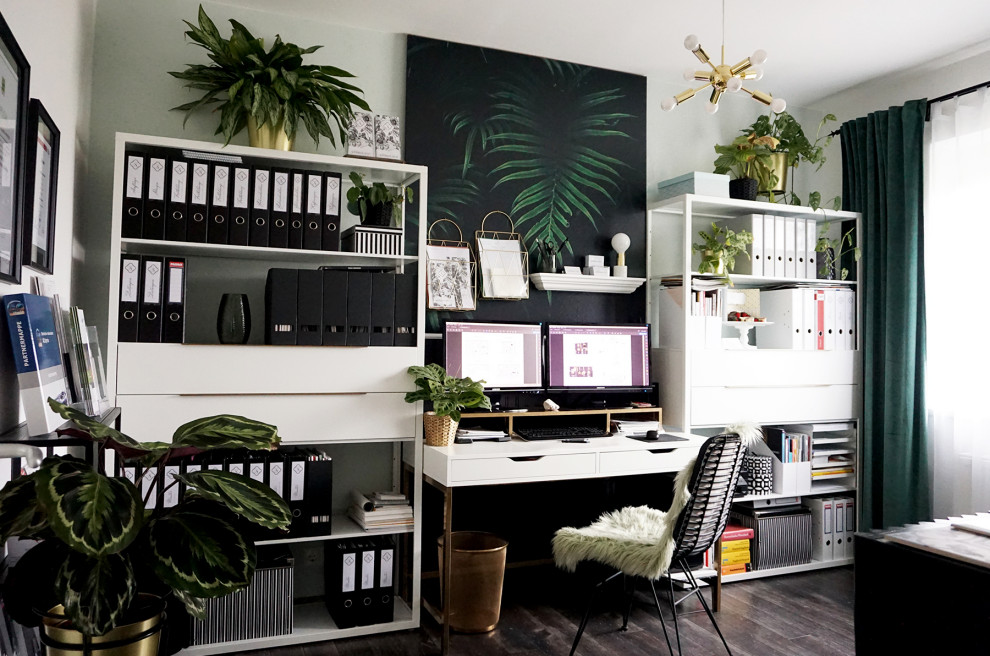 Cette photo montre un bureau éclectique de taille moyenne avec un mur vert, sol en stratifié, un bureau indépendant, un sol marron et du papier peint.