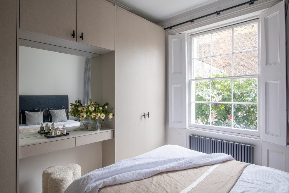 Mittelgroßes Skandinavisches Hauptschlafzimmer mit weißer Wandfarbe, hellem Holzboden, Kamin, verputzter Kaminumrandung und beigem Boden in London