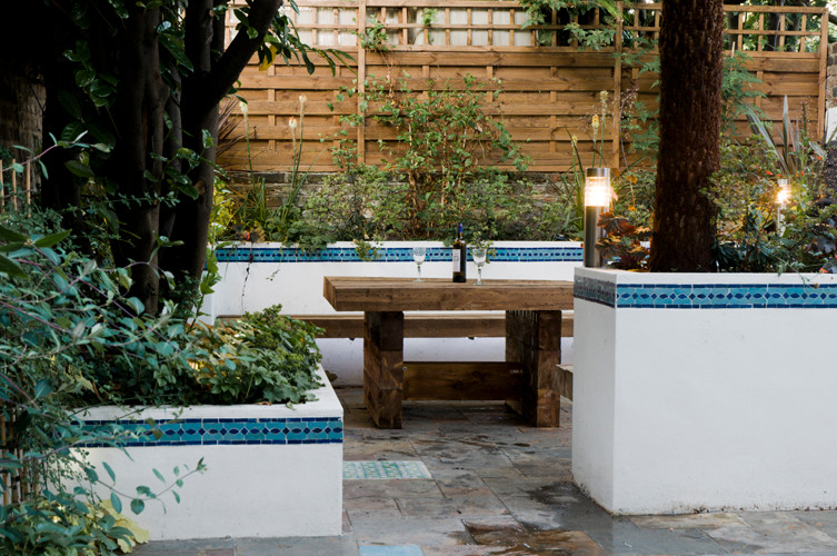 Inspiration for a small country courtyard formal garden in London with river rock.