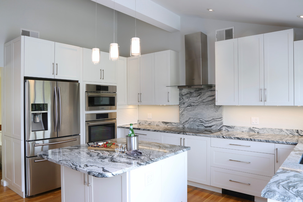 Inspiration for a mid-sized transitional u-shaped eat-in kitchen in Providence with an undermount sink, shaker cabinets, white cabinets, granite benchtops, white splashback, stone slab splashback, stainless steel appliances, medium hardwood floors and with island.