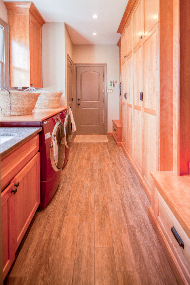 Inspiration for a large traditional galley utility room in DC Metro with recessed-panel cabinets, an undermount sink, granite benchtops, a side-by-side washer and dryer, white walls, medium hardwood floors and medium wood cabinets.