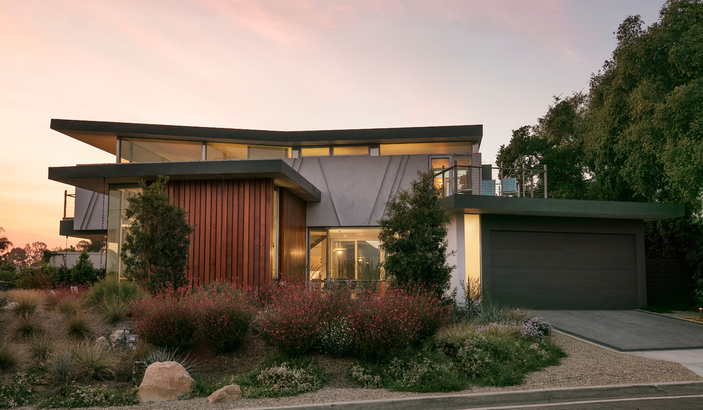 This is an example of a large contemporary two-storey house exterior in Santa Barbara with wood siding and a flat roof.