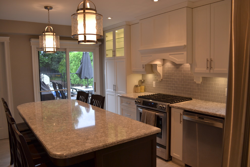 Open concept kitchen - mid-sized transitional single-wall porcelain tile open concept kitchen idea in Toronto with a double-bowl sink, recessed-panel cabinets, white cabinets, quartz countertops, gray backsplash, porcelain backsplash, stainless steel appliances and an island