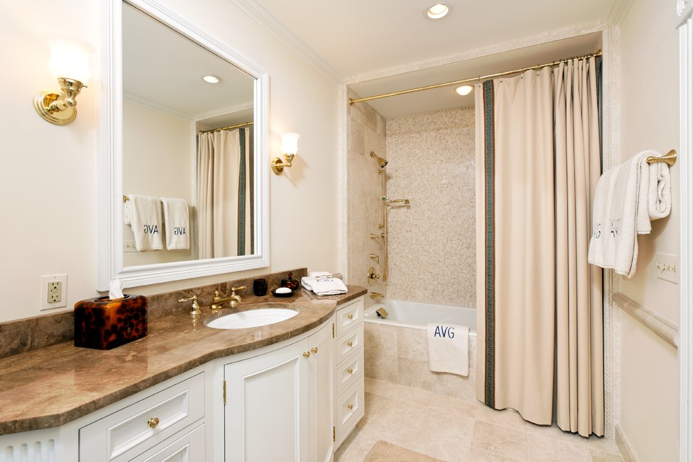 Photo of a traditional master bathroom in DC Metro with an undermount sink, beaded inset cabinets, white cabinets, marble benchtops, a drop-in tub, a shower/bathtub combo, beige tile, porcelain tile, white walls and travertine floors.