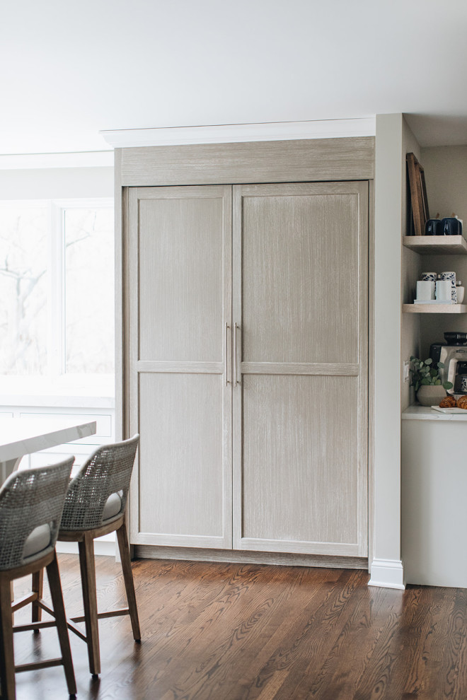 Eat-in kitchen - mid-sized transitional dark wood floor and brown floor eat-in kitchen idea in Chicago with a farmhouse sink, beaded inset cabinets, white cabinets, quartz countertops, paneled appliances, an island and white countertops