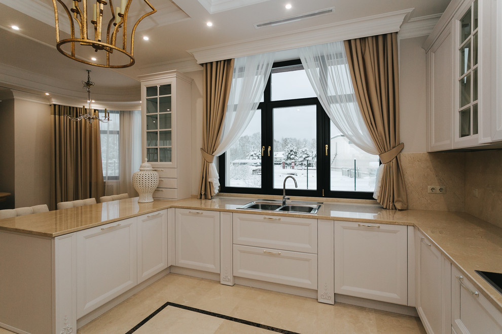 Mid-sized transitional u-shaped separate kitchen in Moscow with beige splashback, porcelain splashback, with island, a drop-in sink, recessed-panel cabinets, white cabinets and beige benchtop.