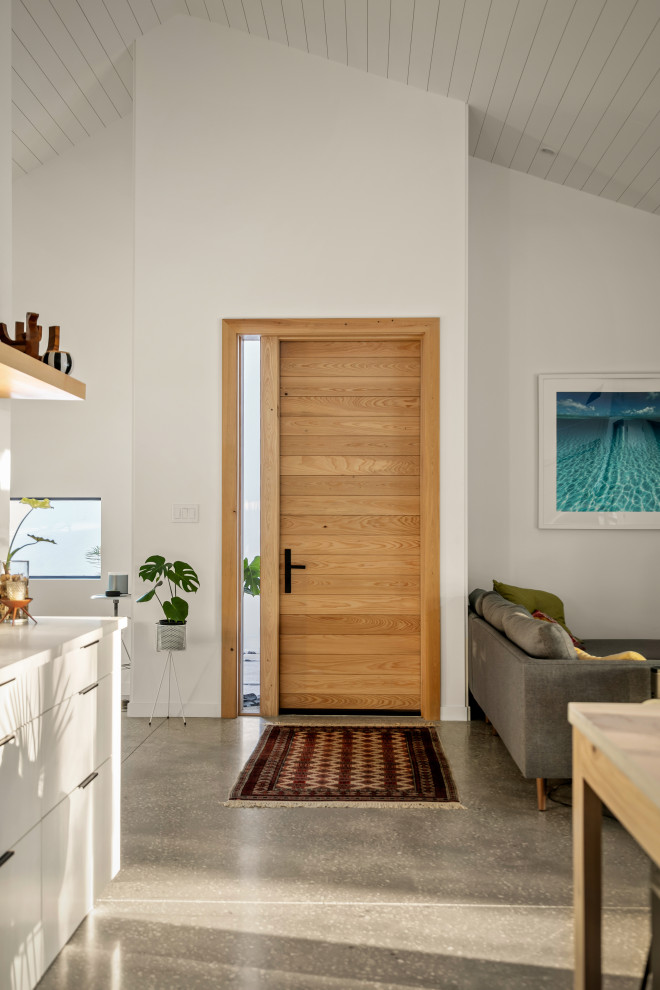 Mid-sized contemporary entry hall in Tampa with white walls, concrete floors, a single front door, a light wood front door, grey floor and timber.