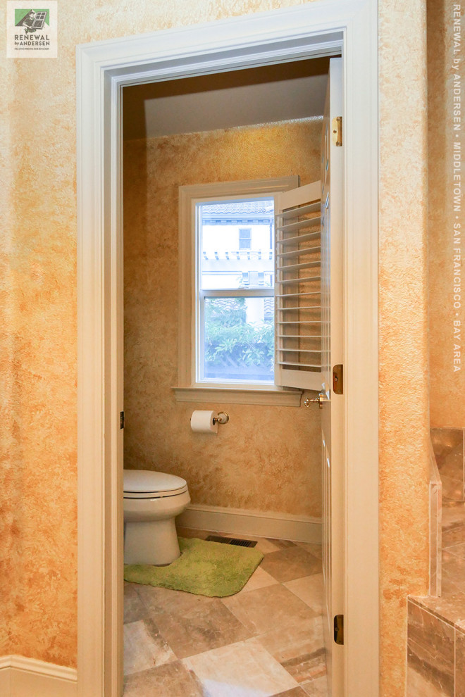 Example of a large master beige tile and ceramic tile marble floor, beige floor, double-sink, vaulted ceiling and wallpaper bathroom design in San Francisco with beige cabinets, a two-piece toilet, beige walls, granite countertops and beige countertops