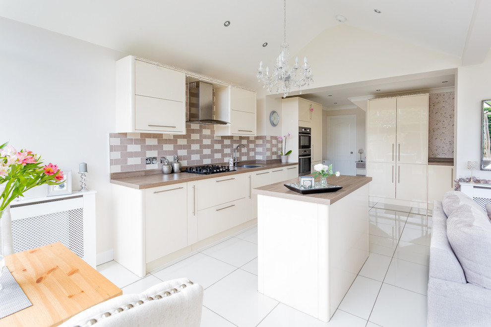 Inspiration for a mid-sized contemporary l-shaped open plan kitchen in Glasgow with a drop-in sink, flat-panel cabinets, beige cabinets, laminate benchtops, beige splashback, ceramic splashback, stainless steel appliances, porcelain floors, with island and white floor.