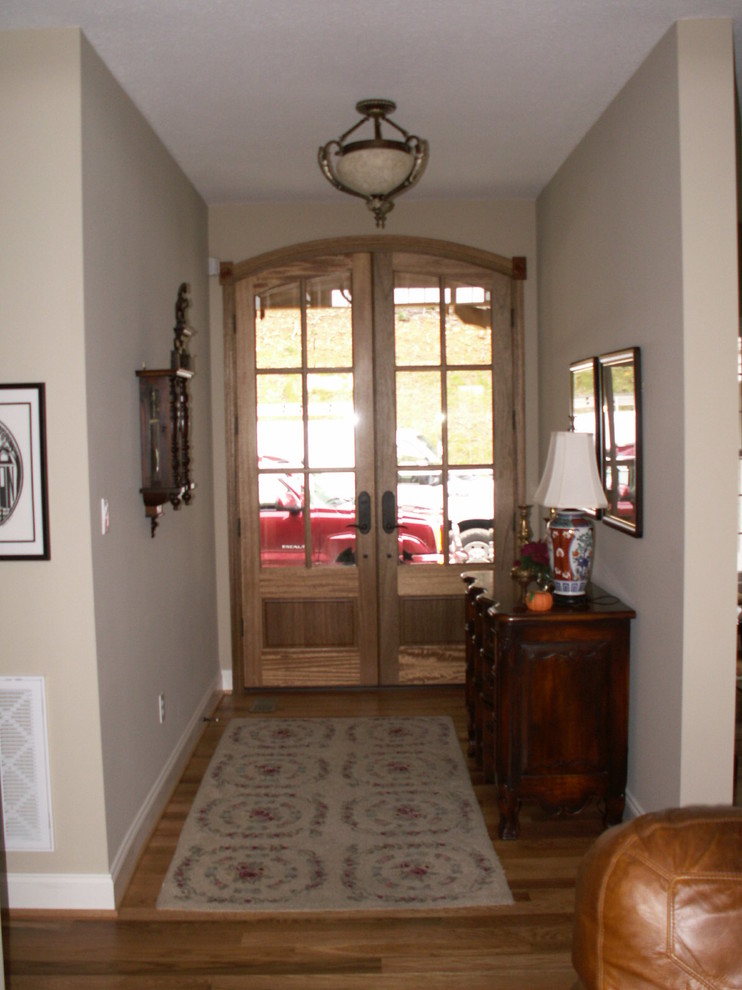 Design ideas for a mid-sized traditional entryway in Other with beige walls, light hardwood floors, a double front door and a glass front door.