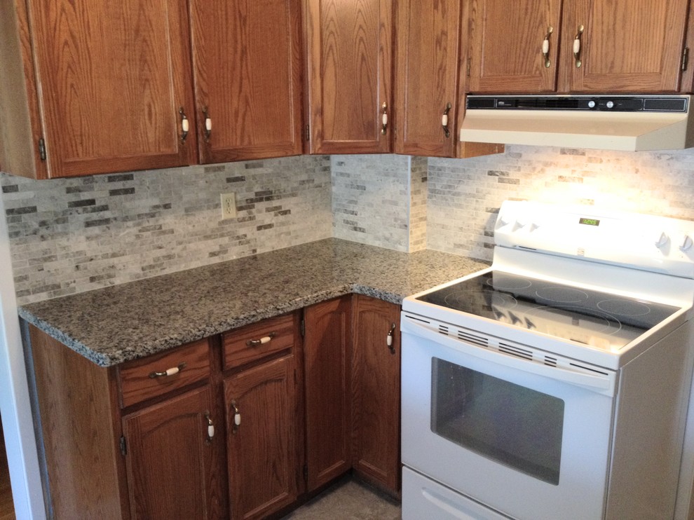 Inspiration for a vinyl floor and gray floor kitchen remodel in Toronto with an undermount sink, granite countertops, gray backsplash, marble backsplash, white appliances and an island