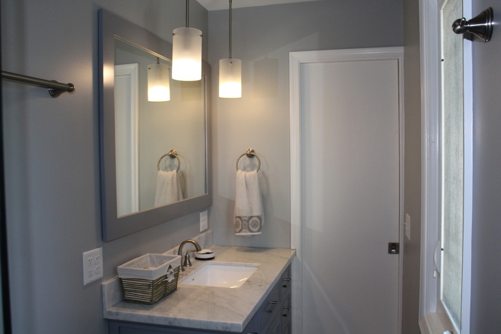 Photo of a small traditional 3/4 bathroom in Other with louvered cabinets, grey cabinets, an alcove tub, an alcove shower, a two-piece toilet, grey walls, an undermount sink, marble benchtops, grey floor and a sliding shower screen.