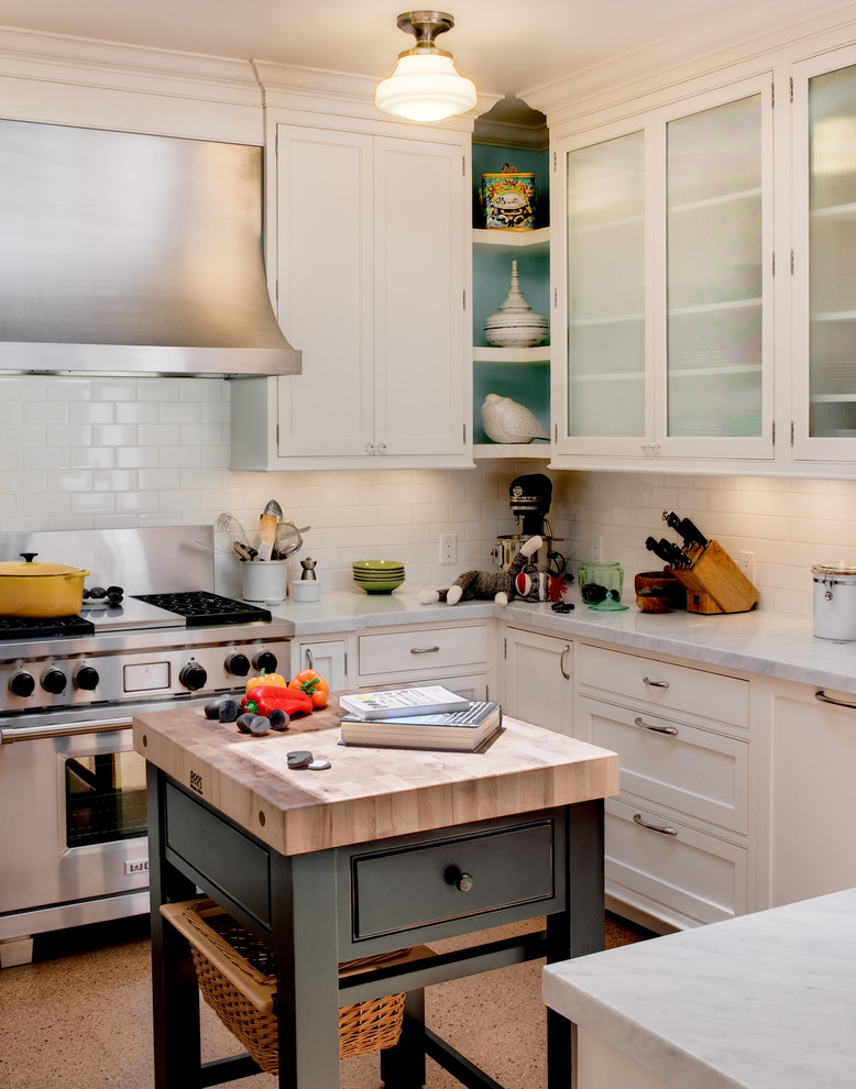 Design ideas for a traditional u-shaped eat-in kitchen in San Francisco with shaker cabinets, white cabinets, white splashback, subway tile splashback, stainless steel appliances, a farmhouse sink and cork floors.