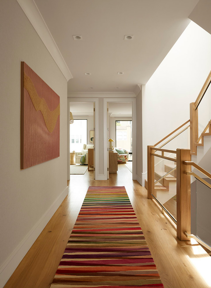 Example of a mid-sized trendy medium tone wood floor hallway design in San Francisco with beige walls