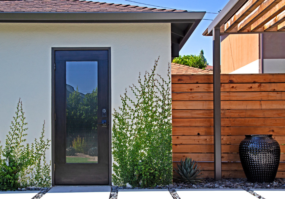 Large modern backyard patio in San Luis Obispo with concrete slab, a pergola and a vertical garden.