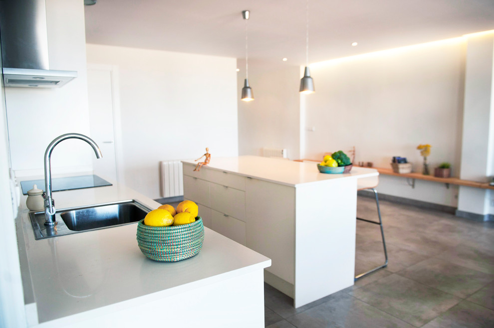 Design ideas for a mid-sized contemporary open plan kitchen in Valencia with an undermount sink, white cabinets, onyx benchtops, white splashback, stone slab splashback, stainless steel appliances, porcelain floors, recessed-panel cabinets and with island.