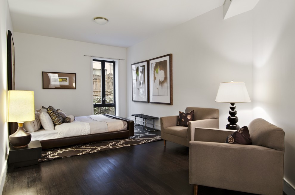 Photo of a contemporary bedroom in New York with white walls and brown floor.