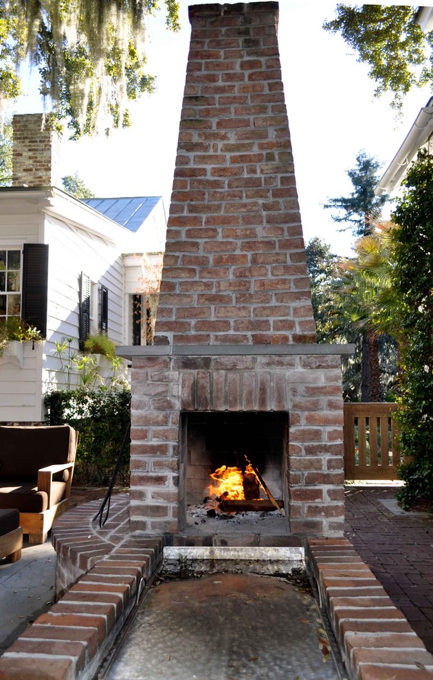 Inspiration for a mid-sized tropical backyard garden in Atlanta with a fire feature and natural stone pavers.
