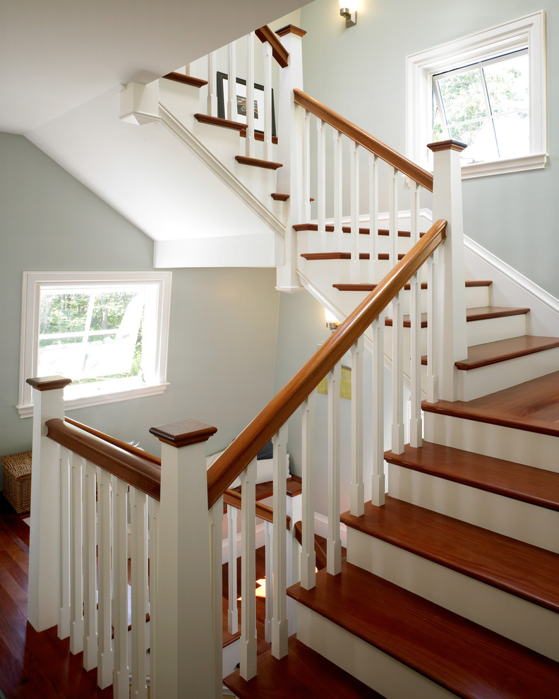 Photo of a large beach style wood u-shaped staircase in Boston with painted wood risers.