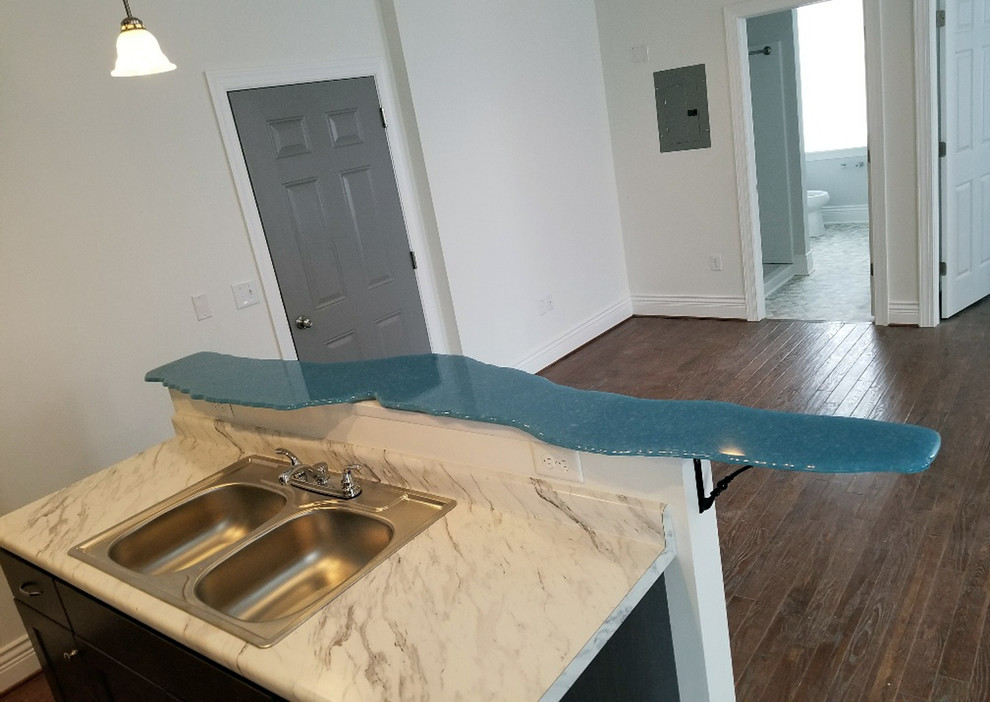 Inspiration for a small transitional galley dark wood floor and brown floor kitchen remodel with a double-bowl sink, recessed-panel cabinets, dark wood cabinets, laminate countertops, white backsplash, an island and white countertops