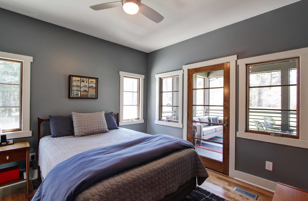 Design ideas for a contemporary guest bedroom in Other with grey walls and light hardwood floors.