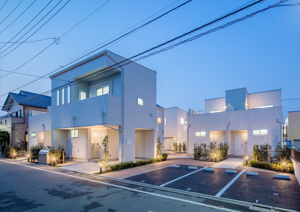 Mid-sized modern two-storey white exterior in Tokyo with mixed siding and a flat roof.