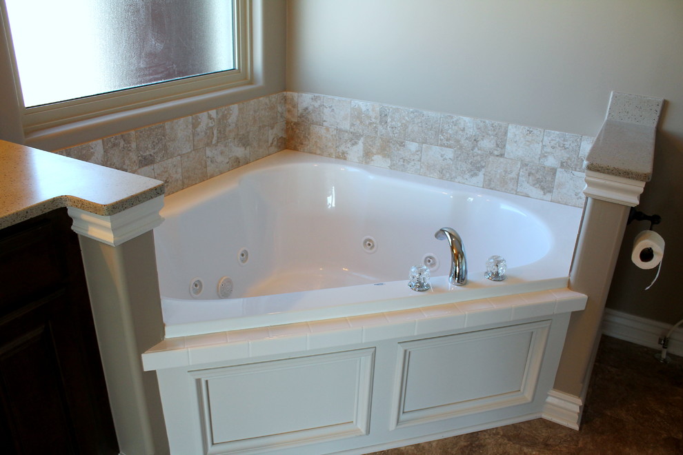 Mid-sized traditional master bathroom in Wichita with raised-panel cabinets, dark wood cabinets, a corner tub, an alcove shower, a two-piece toilet, beige tile, ceramic tile, beige walls, linoleum floors, an undermount sink and engineered quartz benchtops.