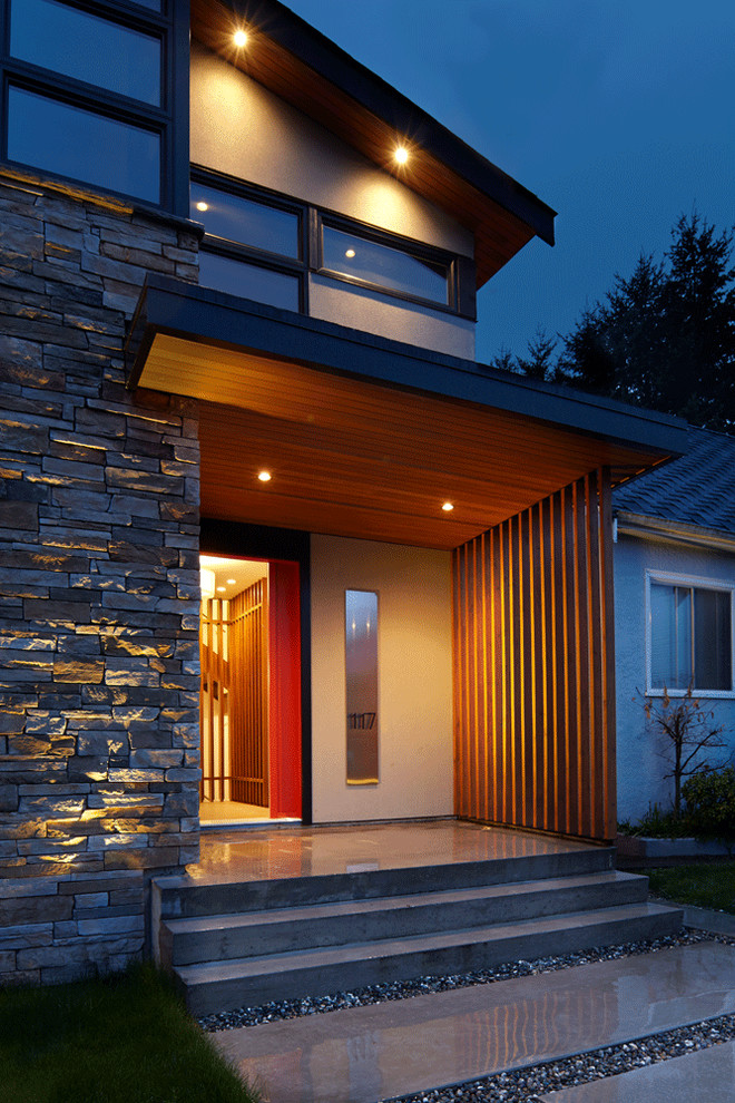 Design ideas for a mid-sized contemporary two-storey grey house exterior in Vancouver with stone veneer.