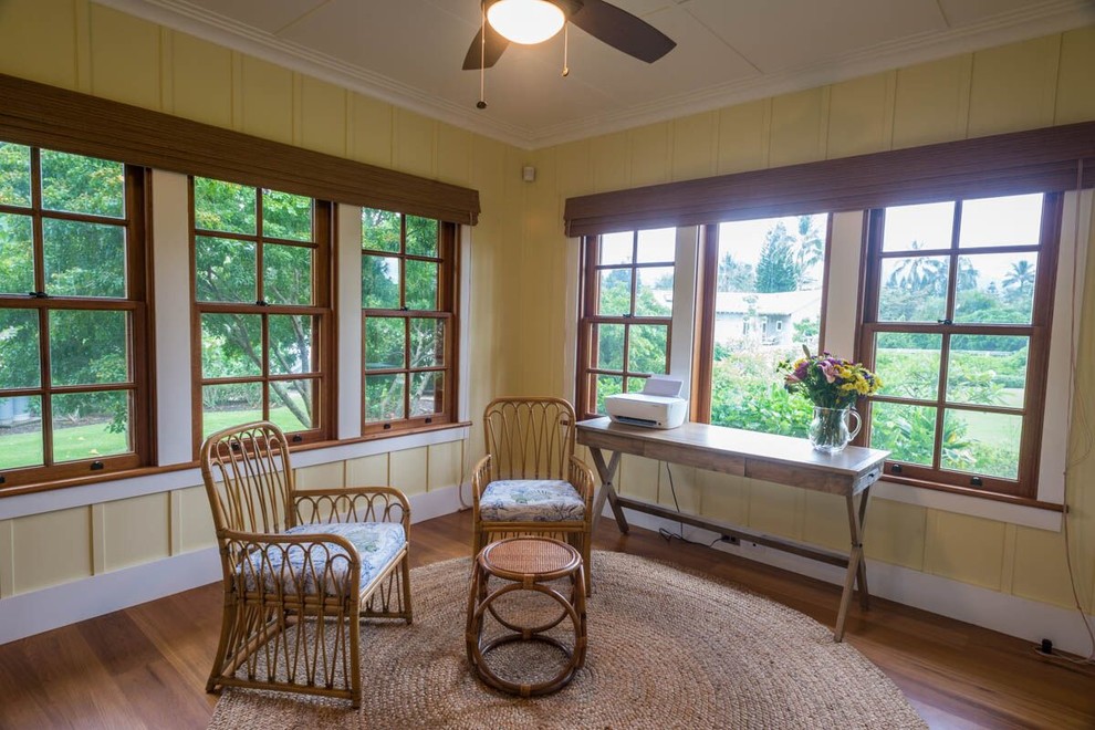 Photo of a mid-sized country home office in Hawaii with yellow walls, light hardwood floors, a freestanding desk and brown floor.