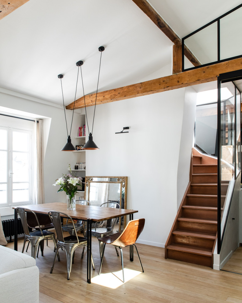 Inspiration for a contemporary dining room in Paris with white walls, light hardwood flooring and exposed beams.
