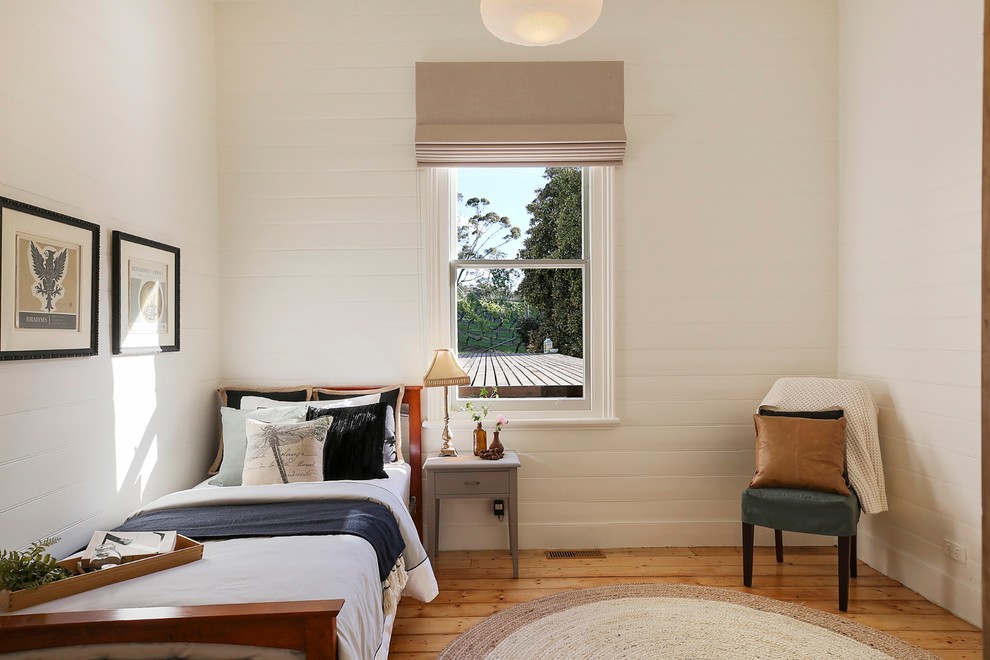 Design ideas for a transitional bedroom in Geelong with white walls, medium hardwood floors and brown floor.