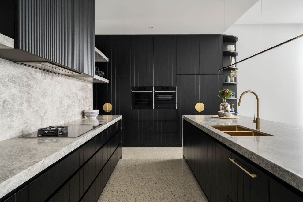 Inredning av ett modernt stort grå grått kök, med en dubbel diskho, svarta skåp, marmorbänkskiva, grått stänkskydd, stänkskydd i marmor, svarta vitvaror, betonggolv, en köksö och grått golv