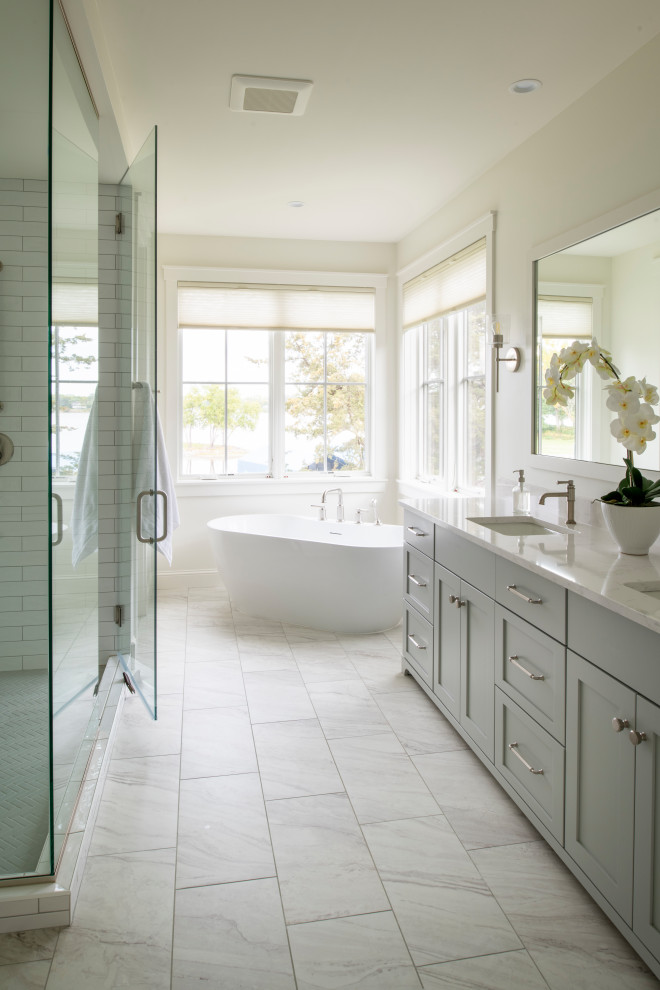 Inspiration for a transitional white tile and subway tile white floor and double-sink freestanding bathtub remodel in Minneapolis with shaker cabinets, gray cabinets, white walls, an undermount sink, a hinged shower door, white countertops, a built-in vanity and quartz countertops