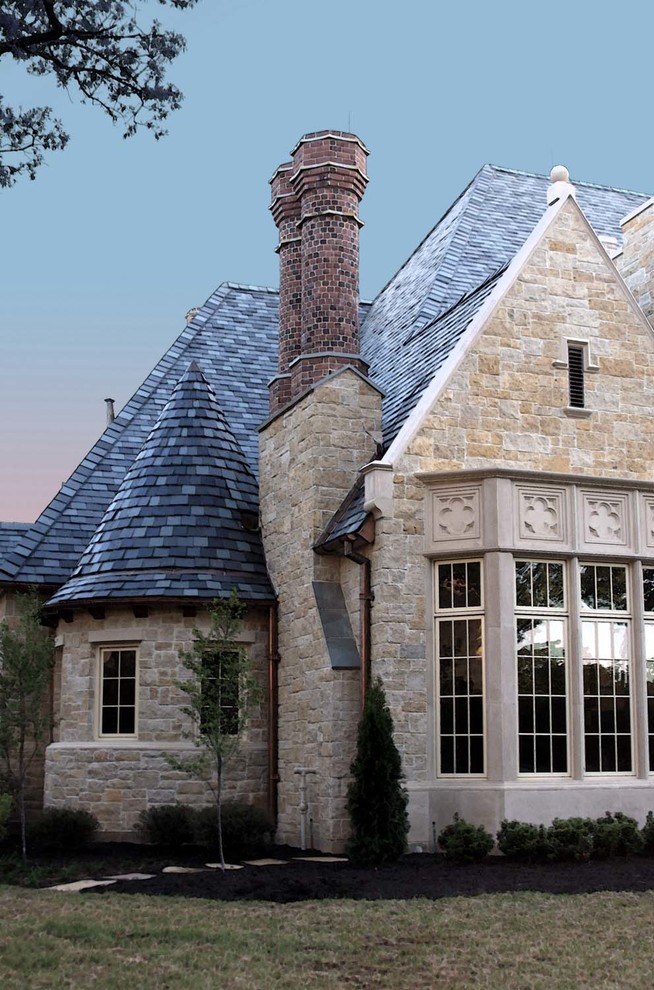 Photo of a large traditional two-storey beige house exterior in Dallas with stone veneer.