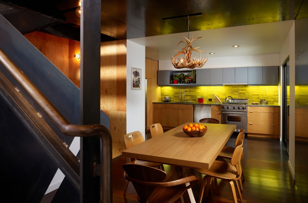This is an example of a small contemporary single-wall eat-in kitchen in San Francisco with a drop-in sink, flat-panel cabinets, light wood cabinets, concrete benchtops, yellow splashback, ceramic splashback, stainless steel appliances and dark hardwood floors.